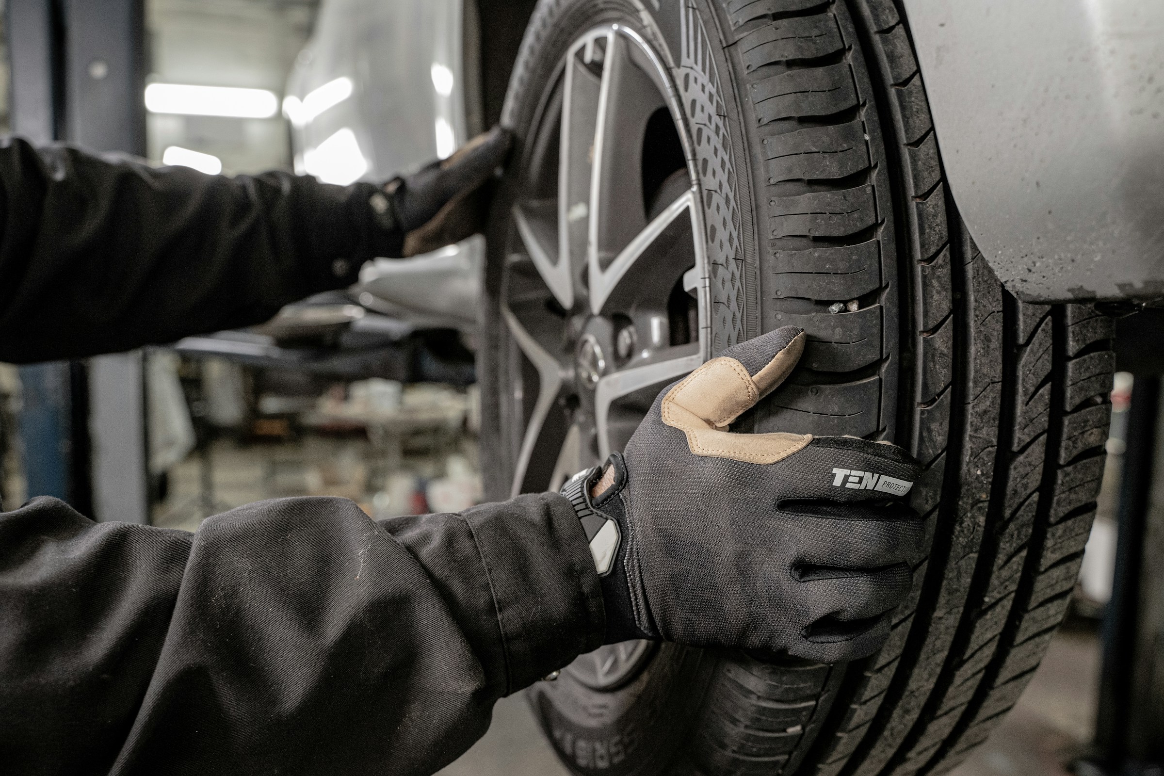 mechanic putting a wheel on a car