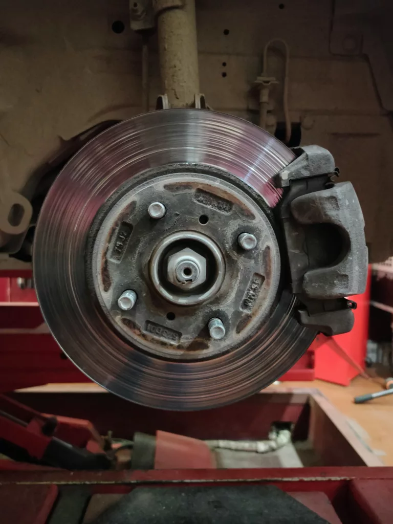 Close-up of a car’s disc brake and caliper during brake service at an auto repair shop in Calgary, AB